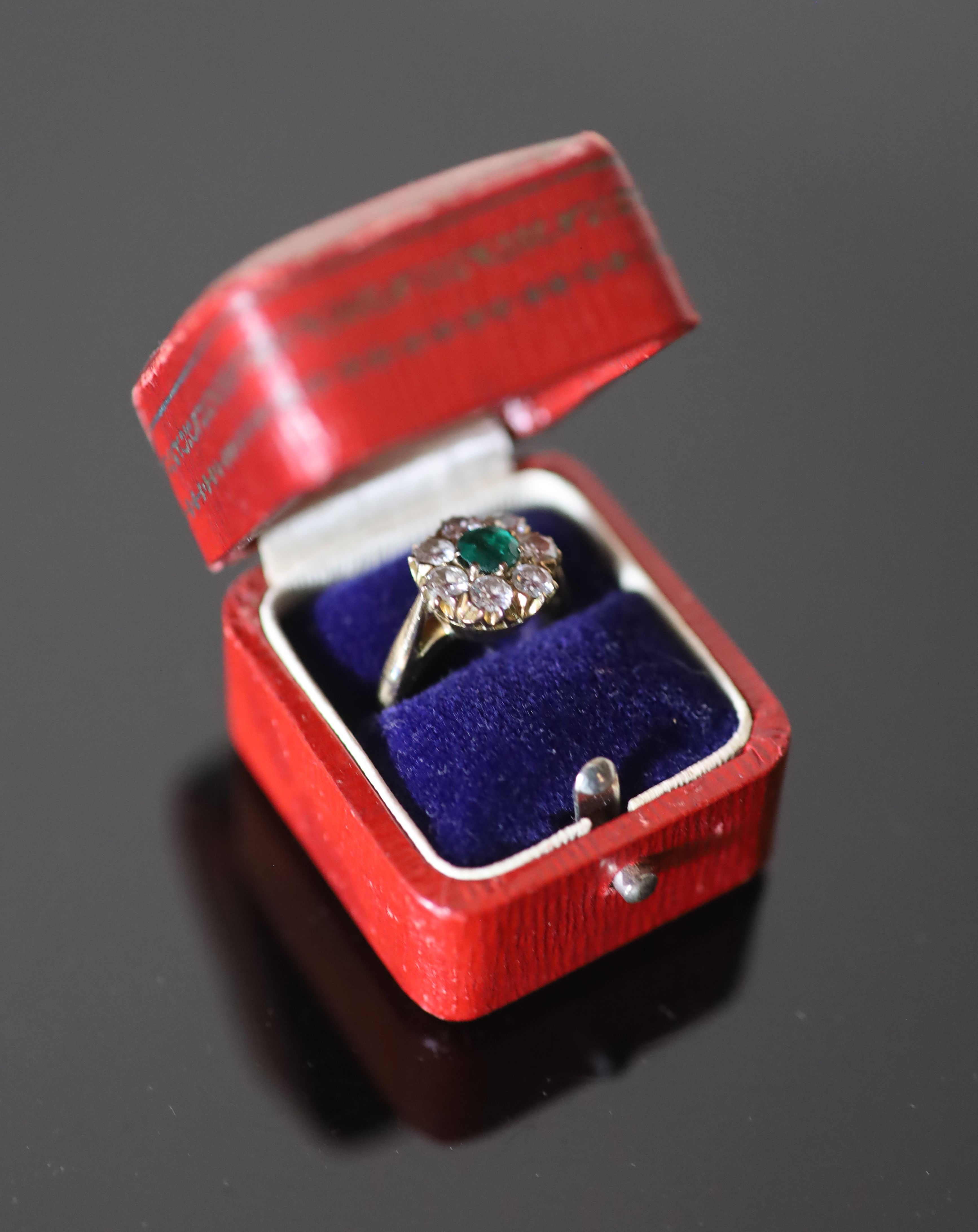 A 20th century gold, emerald and diamond set circular eight stone cluster ring,